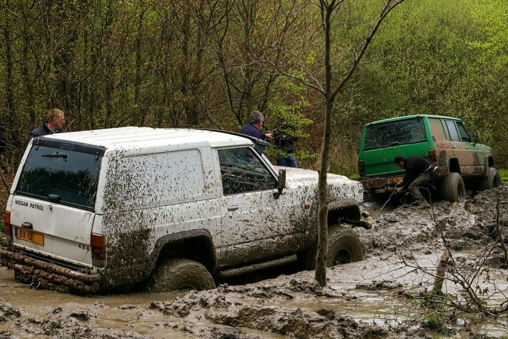 Nissan vehicles engaged in challenging off-road mud adventure in Stadtoldendorf, Germany.