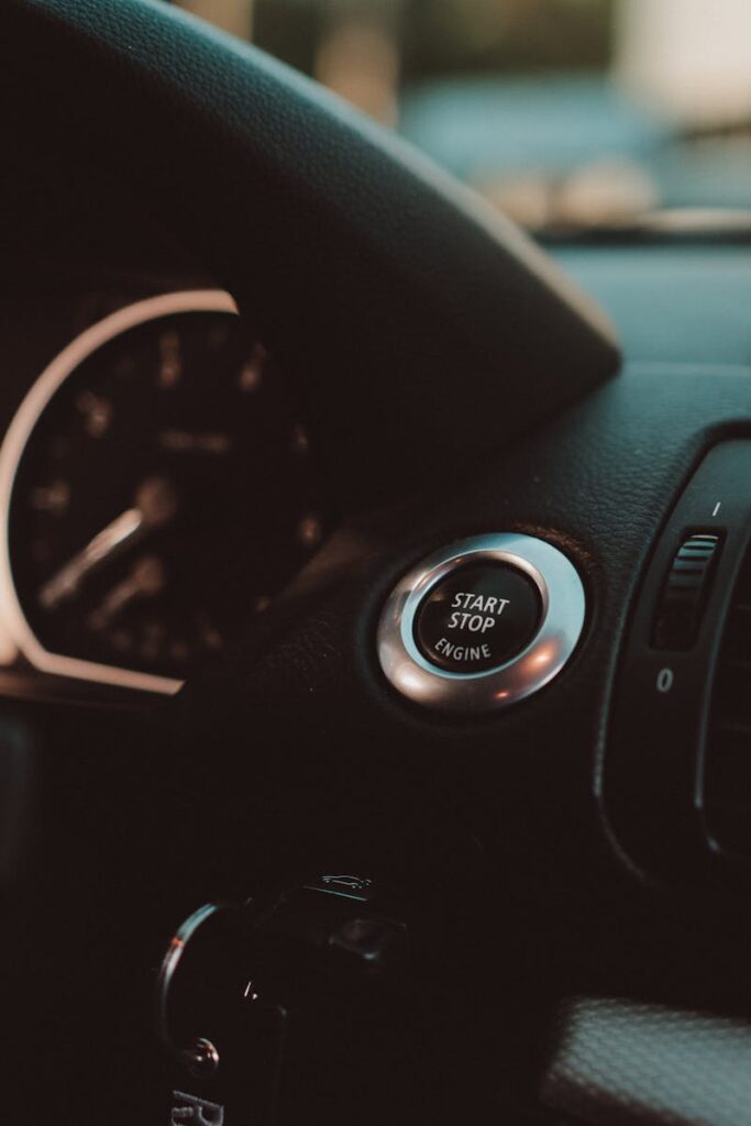 Close-up of a luxury car dashboard featuring a start stop button and sleek design.