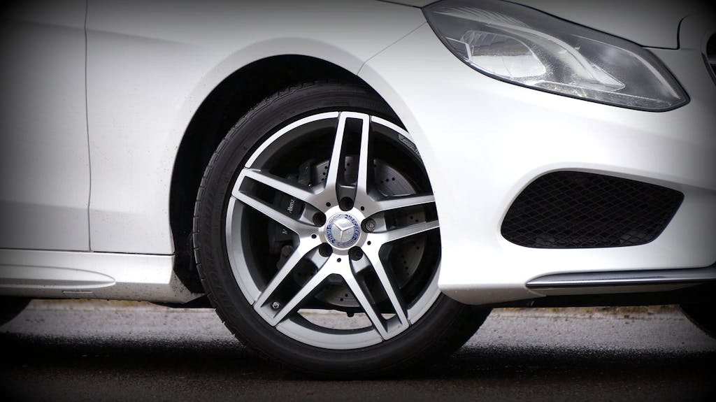 Detailed view of a luxury car's wheel and headlight, showcasing design.