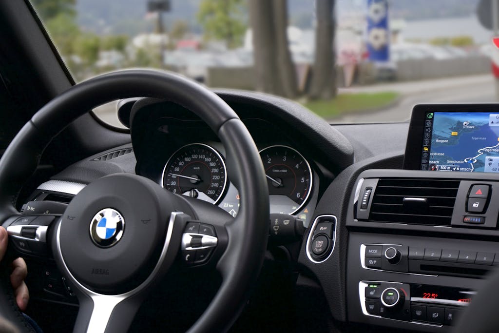 Elegant BMW car interior showcasing navigation screen, speedometer, and steering wheel.