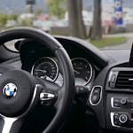 Elegant BMW car interior showcasing navigation screen, speedometer, and steering wheel.