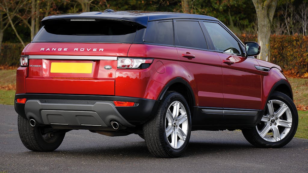 Elegant red Range Rover SUV parked outdoors on a clear day, showcasing its luxury and style.