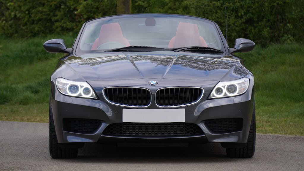 Front view of a luxurious BMW Z4 convertible car on a picturesque road, showcasing sleek design.