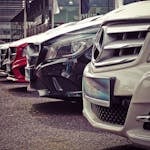 Luxury cars lined up at an outdoor dealership, showcasing sleek designs.